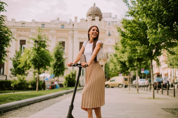 Young woman riding an electric scooter on a street