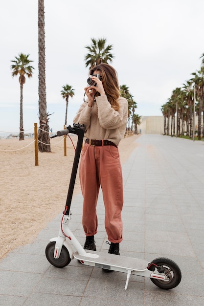 Foto giovane donna in sella a uno scooter elettrico