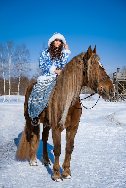 Young woman riding a horse in winter