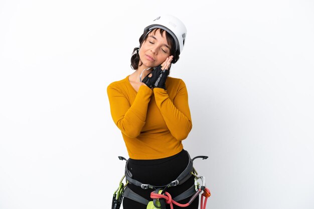 Young woman rockclimber woman isolated on white background making sleep gesture in dorable expression