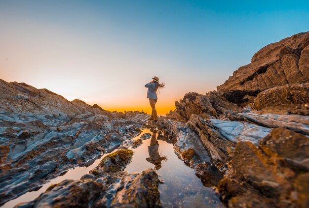 a young woman on the rocks by the sea