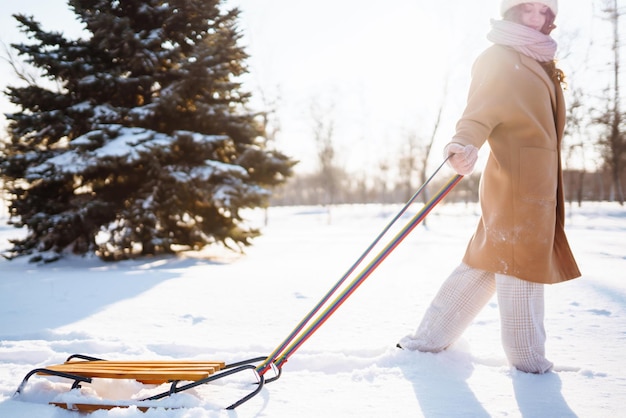 Young woman rolls on a sled in the winter snowy forest Nature holidays rest travel concept