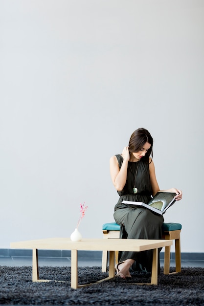 Young woman in the room with a book