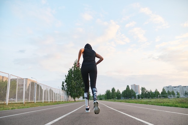 Young woman runner running at the stadium outdoor.