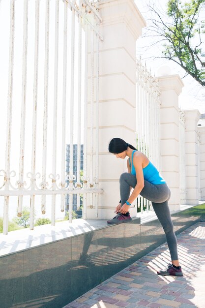 Young woman runner tying shoelaces