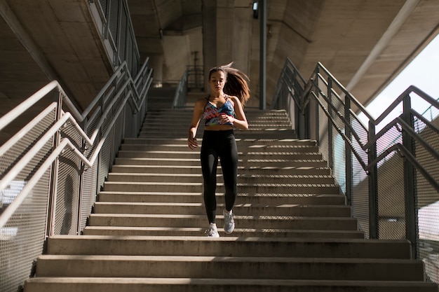 一人で階段を下って走っている若い女性