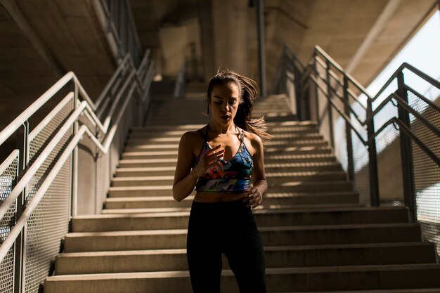 Young woman running alone down stairs