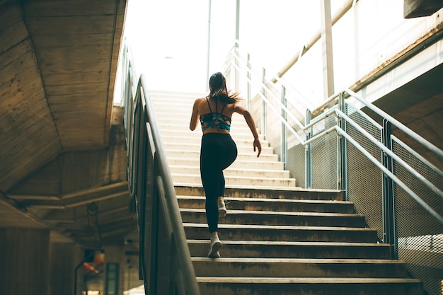 Young woman running alone up stairs