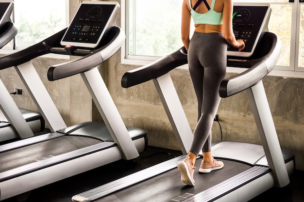 Giovane donna che corre sul tapis roulant in palestra