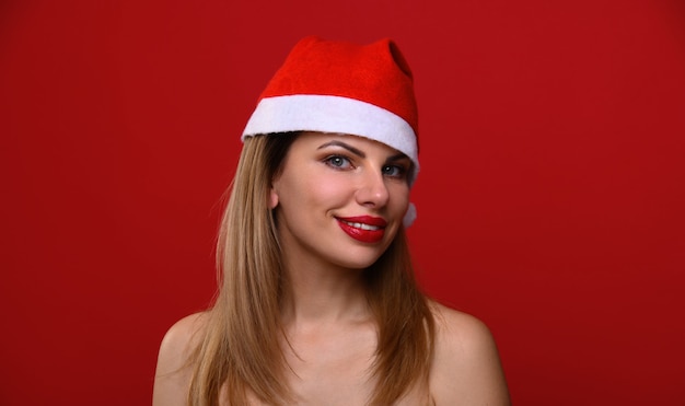 Foto la giovane donna con un cappello da babbo natale sorride.