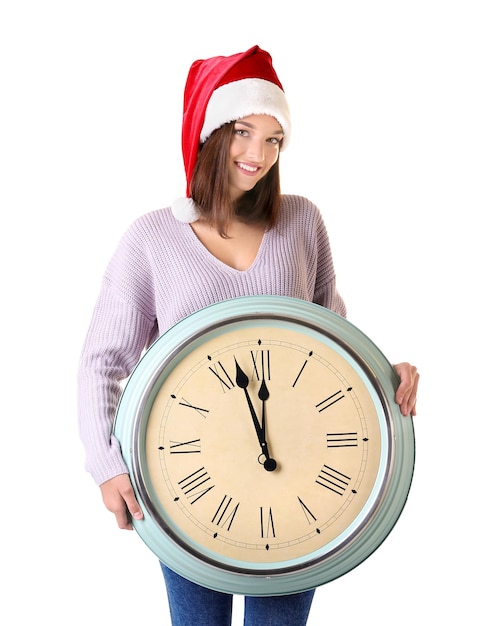 白い背景の上の時計とサンタ帽子の若い女性。クリスマスのカウントダウンの概念