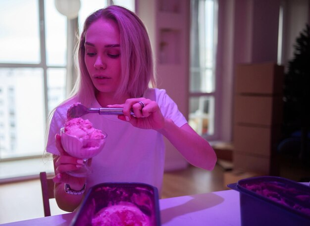 Photo young woman scooping ice cream at home containers