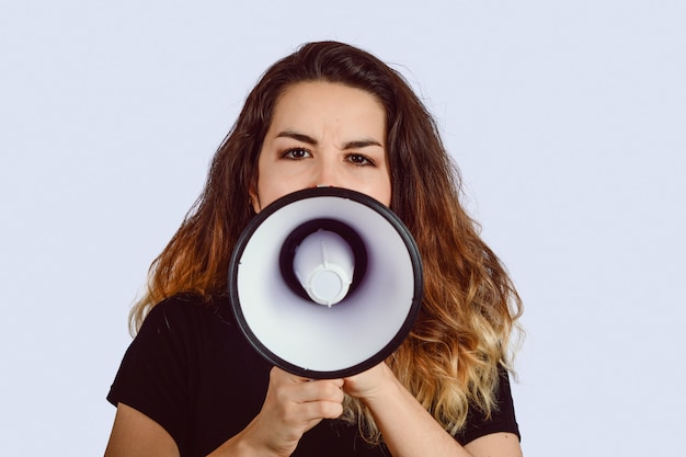 Young woman screaming on a megaphone 