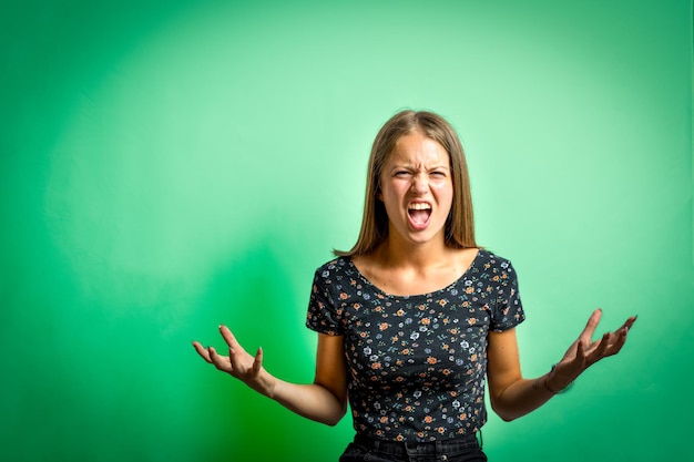 Photo young woman screaming with raised arms and hands, copy space