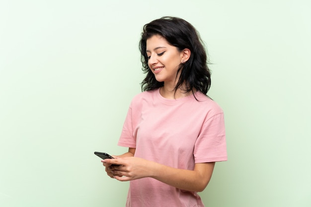 Young woman sending a message with the mobile