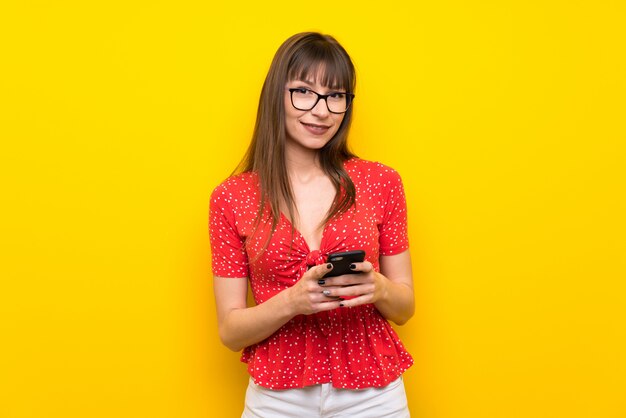 Young woman sending a message with the mobile