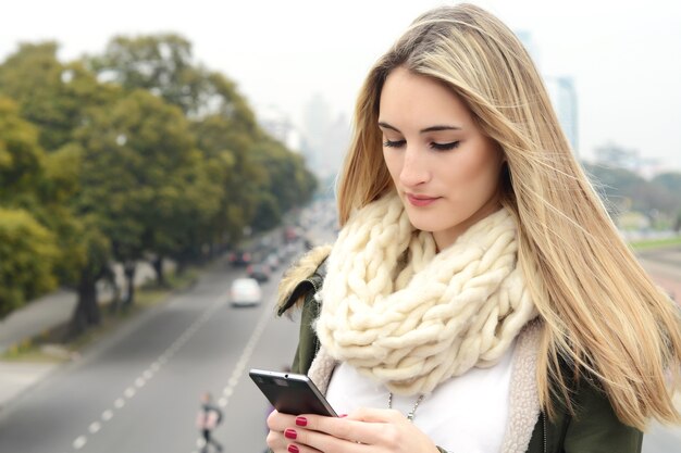 Young woman sending messages with her smartphone.