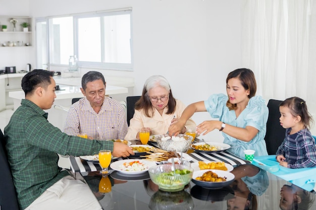 Young woman serving foods for her big family