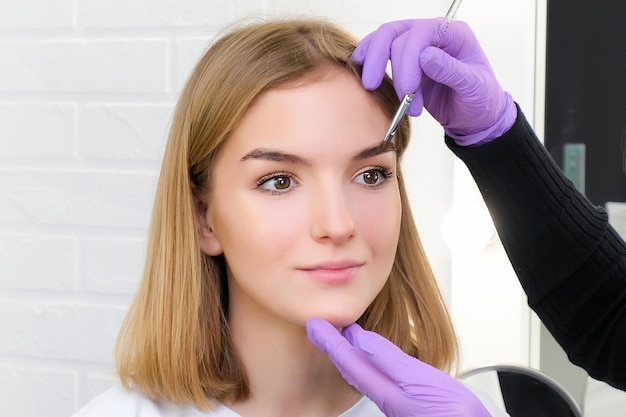 Young woman shaping eyebrows with brush, close up