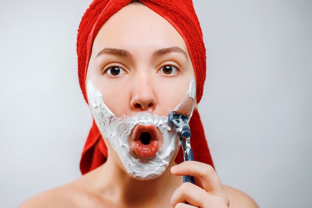 young woman shaves her beard with a razor emotional gender role