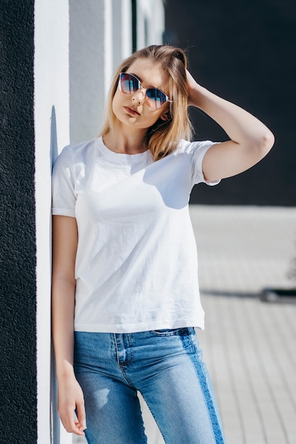 Giovane donna in camicia e jeans in posa all'aperto