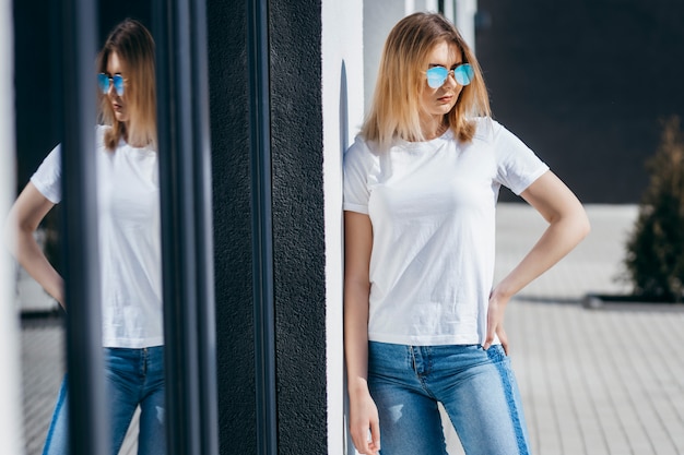 Young woman in shirt and jeans posing outdoors