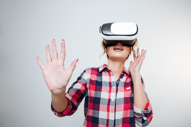 Молодая женщина в рубашке с помощью устройства виртуальной реальности