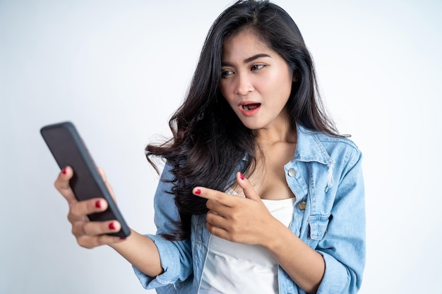 Young woman shocked while using mobile phone