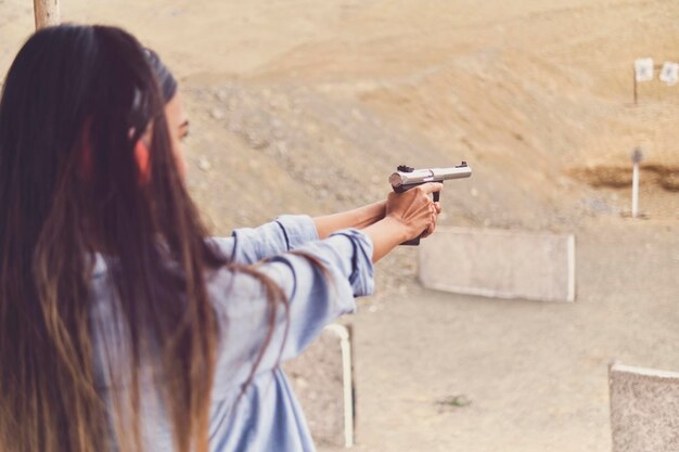 銃を撃つ若い女性