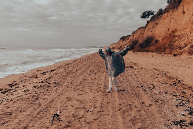 Young woman shoots a vlog on the cold seashore