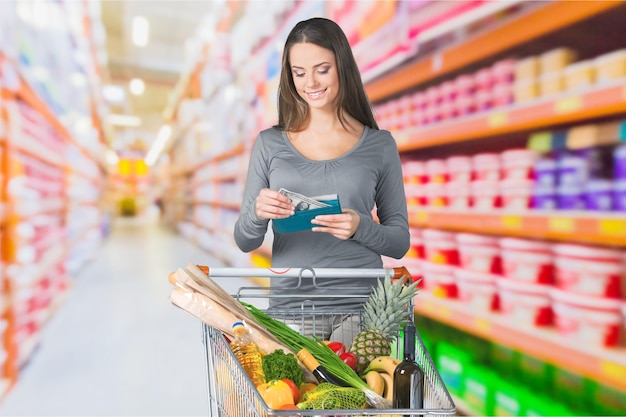 Young woman shopping in grocery store with shopping cart