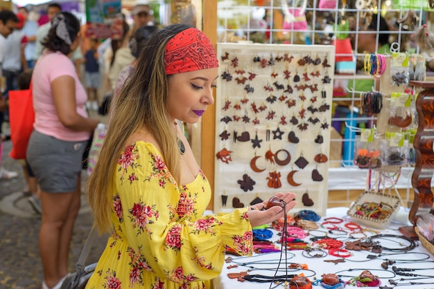 Молодая женщина делает покупки на мексиканском рынке изделий ручной работы