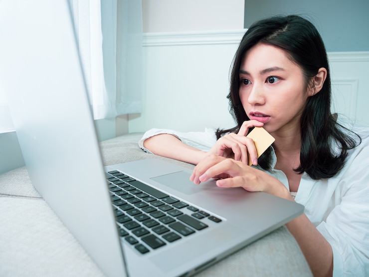 Photo young woman shopping online with credit card and laptop at home