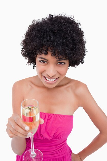 Молодая женщина, показывая сияющая улыбка, держа бокал шампанского