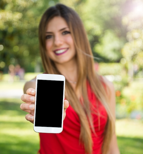 Foto giovane donna che mostra uno schermo vuoto dello smartphone