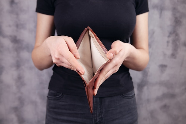 Young woman showing empty wallet