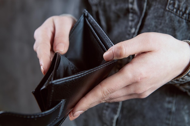 Young woman showing empty wallet