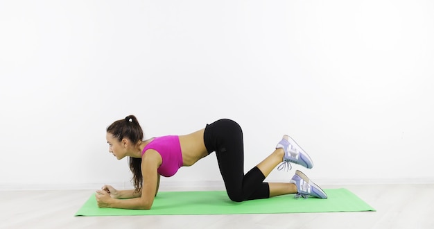 Young woman showing medical exercises in the gym Beautiful body and healthy lifestyle