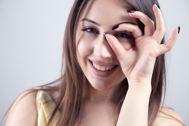 Foto giovane donna che mostra il segno giusto sopra gli occhi