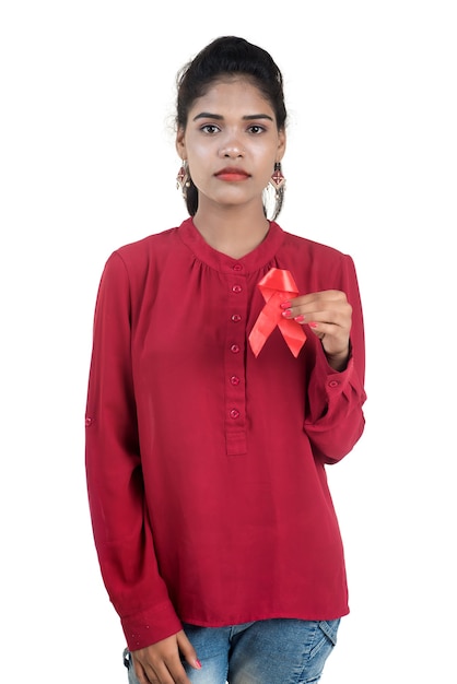赤いリボンHIV、エイズ意識リボン、ヘルスケアと医学の概念を示す若い女性
