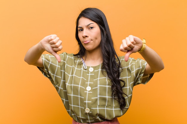 Young woman showing thumbs down in disagreement