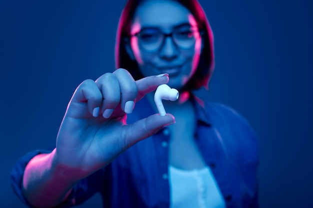 Young woman showing true wireless earbuds