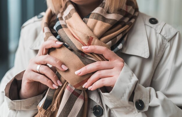 young woman shows off a beautiful autumn stylish scarf and coat. Autumn style concept