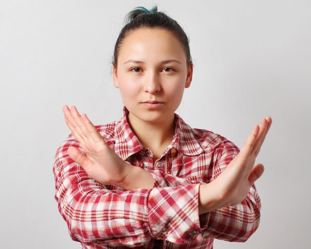 Photo young woman shows two crossed arms in front of him stop sign.