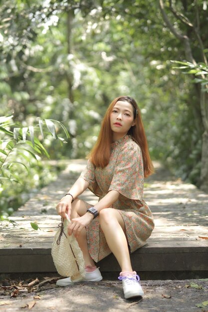 Young woman siitting on wood foot walk