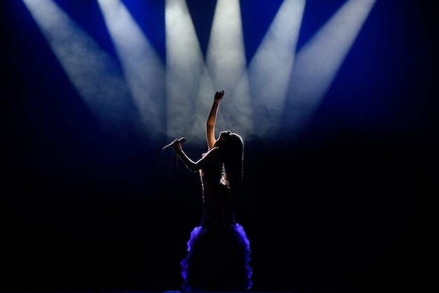 A young woman singer on stage during a concert.