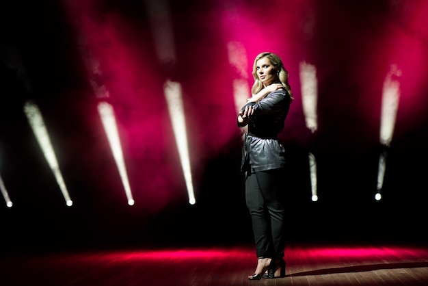 Young woman singer with colorful lights on concert