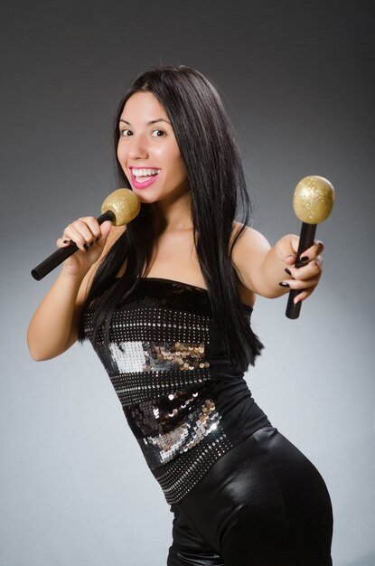 Photo young woman singing in karaoke club