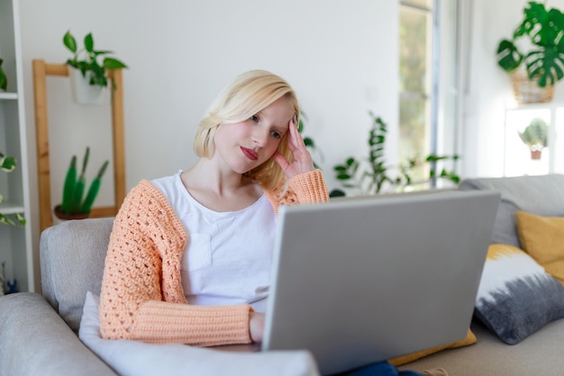 Young woman sit at home office reading email or contract feel confused with bad news frustrated woman stunned by received paperwork correspondence