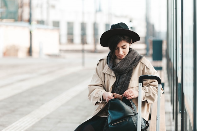 Young woman sits at a public transport stop